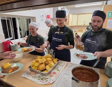 Kitchen team are plating up main courses at the kitchen hatch